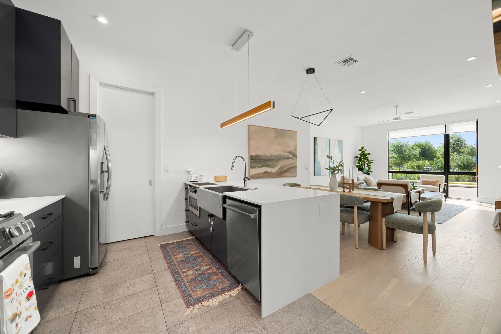 An open kitchen layout flows seamlessly into light-filled living spaces with modern fixtures throughout.