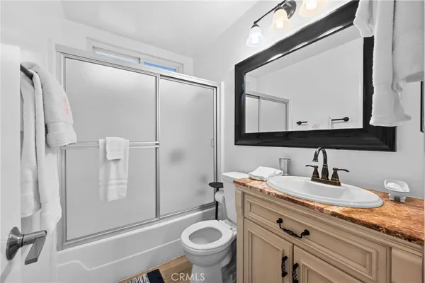 a bathroom with a granite countertop sink toilet and shower