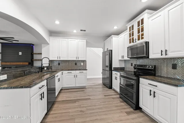 a view of a livingroom with a flat screen tv wooden floor and a ceiling fan