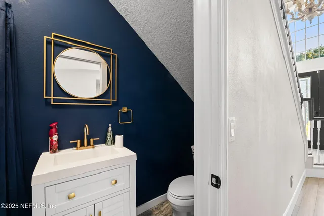 a view of an empty room with a window and a kitchen with wooden floor