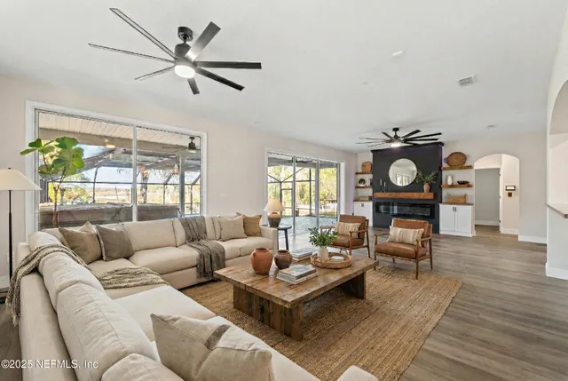 a view of a livingroom with a ceiling fan and wooden floor
