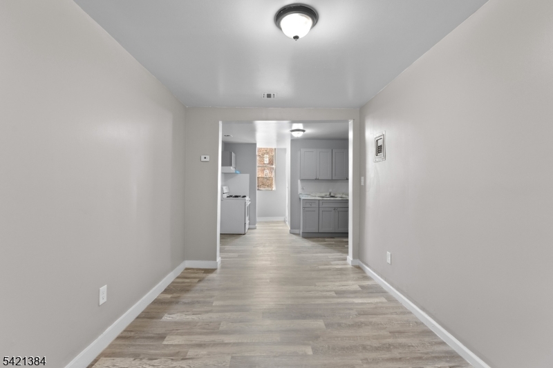 23 Monroe Street, Unit 2 Passaic, NJ 07055 - Photo 3 of 13 a view of a hallway with wooden floor