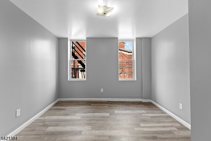23 Monroe Street, Unit 2 Passaic, NJ 07055 - Photo 6 of 13 a view of empty room with wooden floor