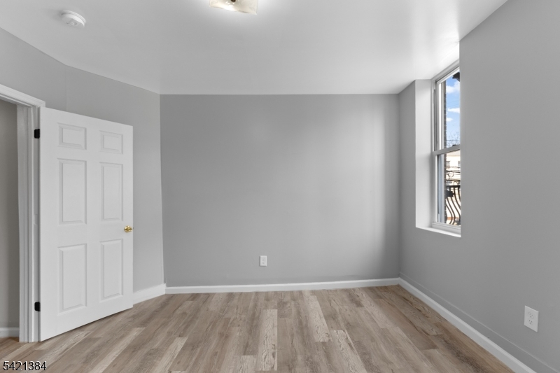 23 Monroe Street, Unit 2 Passaic, NJ 07055 - Photo 7 of 13 wooden floor in an empty room with a window