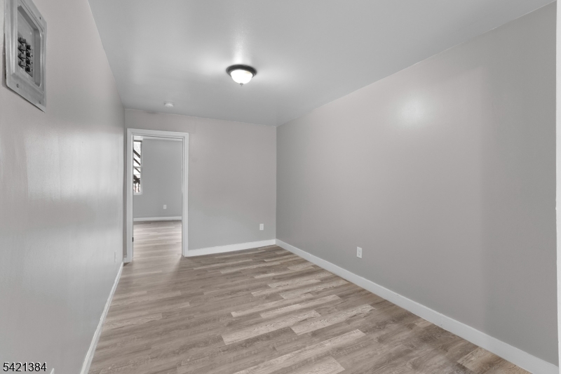 23 Monroe Street, Unit 2 Passaic, NJ 07055 - Photo 10 of 13 a view of an empty room with wooden floor and closet