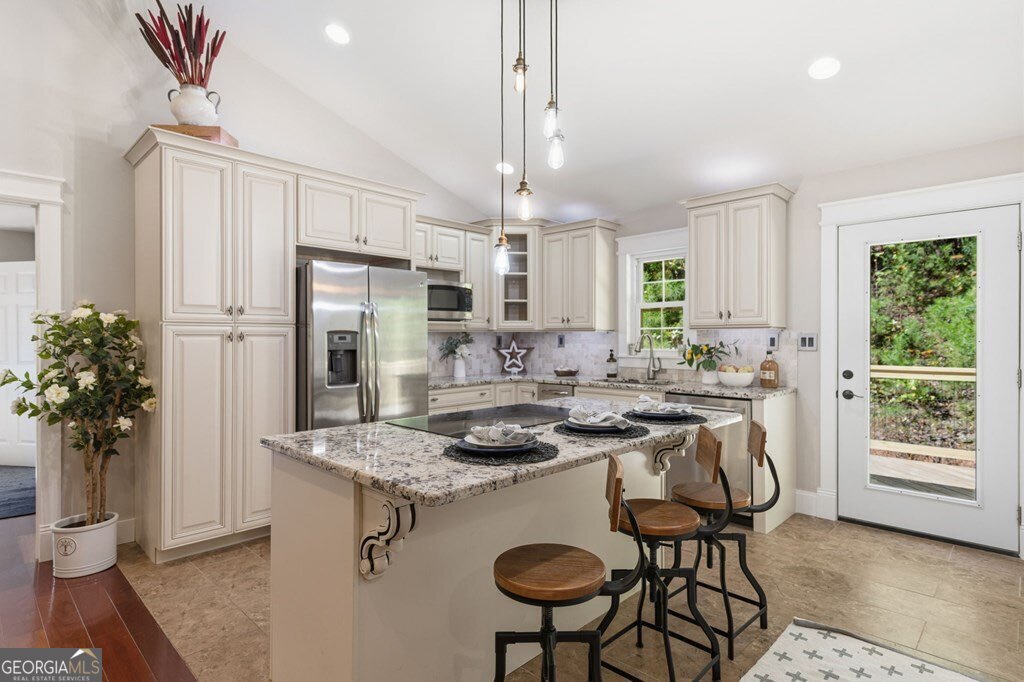 224 Timber Ridge Lane Ellijay, GA 30540 - Photo 27 of 61 a kitchen with stainless steel appliances granite countertop a stove a refrigerator a sink dishwasher a dining table and chairs with wooden floor