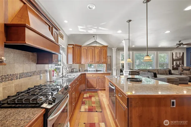 a kitchen with stainless steel appliances granite countertop a sink stove and refrigerator