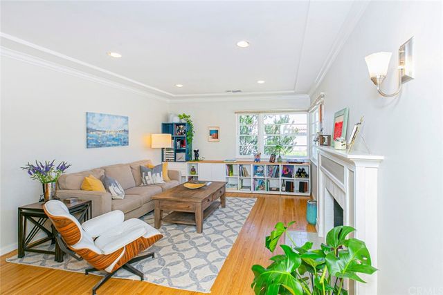a living room with furniture fireplace and potted plants