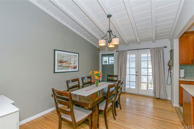 a view of a hallway with dining room and wooden floor