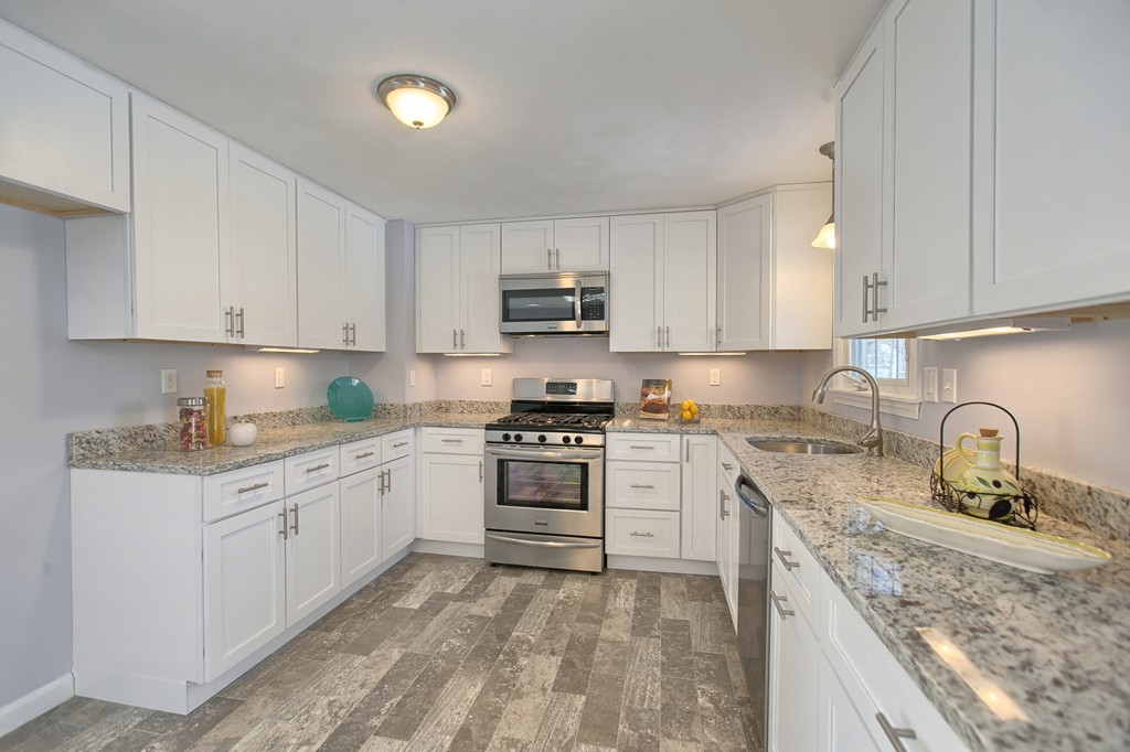 6 Campbell Road Billerica, MA 01821 - Photo 7 of 30 a kitchen with granite countertop a sink stove and cabinets