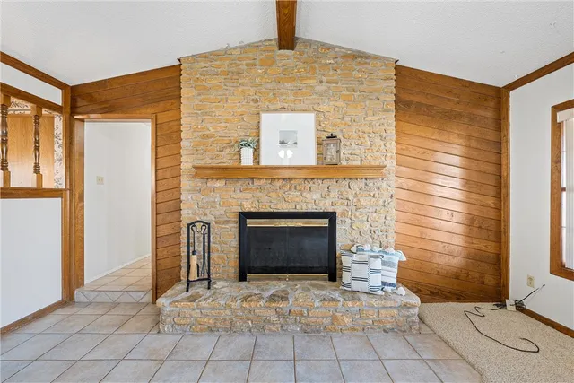 a view of an empty room with chandelier fan and fireplace