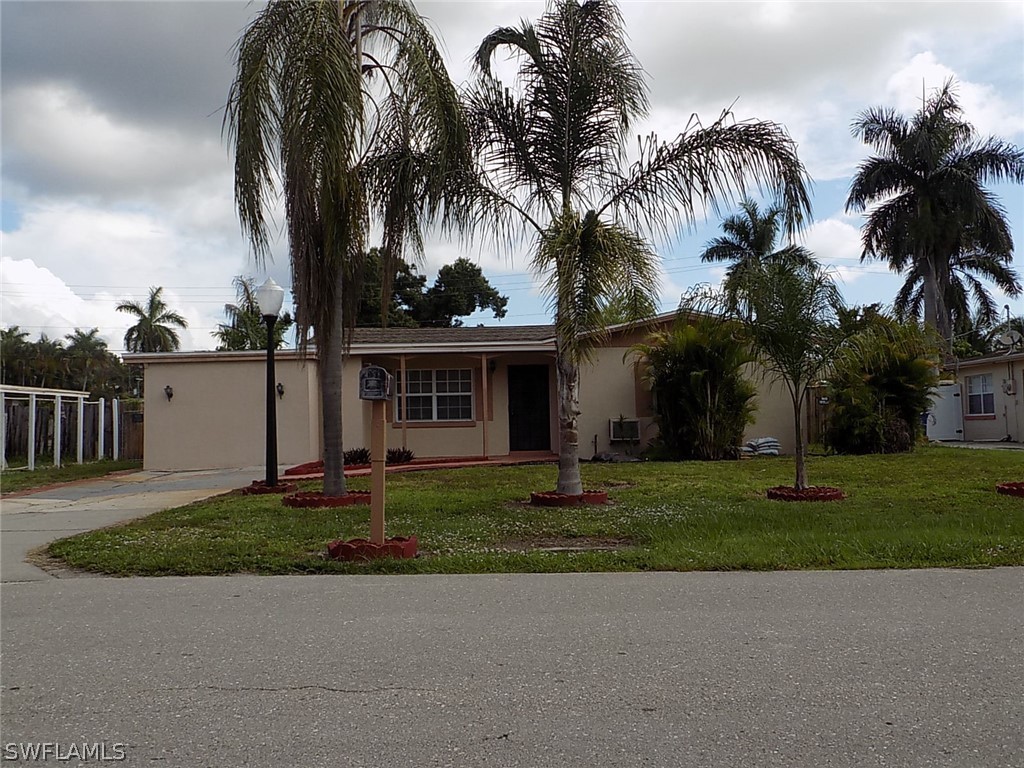 2105 Pineview Road Fort Myers, FL 33901 - Photo 3 of 22 front view of a house with a yard and palm trees