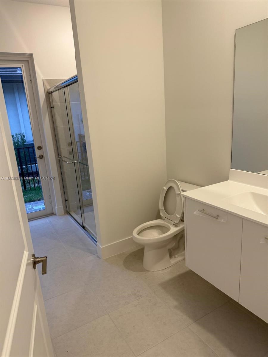 12303 Southwest 44th Street Davie, FL 33330 - Photo 12 of 42 a bathroom with a sink a toilet a mirror and vanity