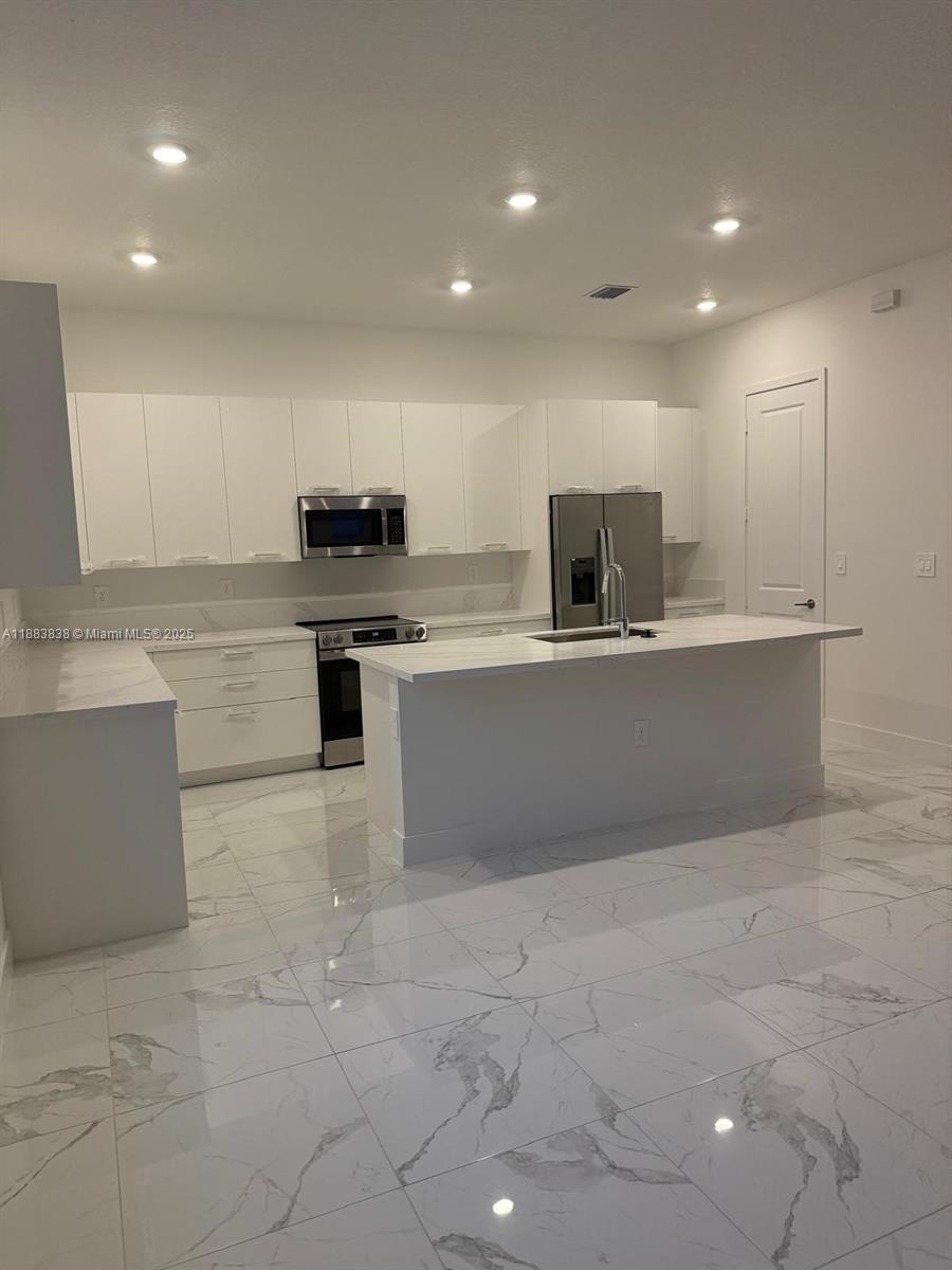 12303 Southwest 44th Street Davie, FL 33330 - Photo 14 of 42 a kitchen with kitchen island sink and stove
