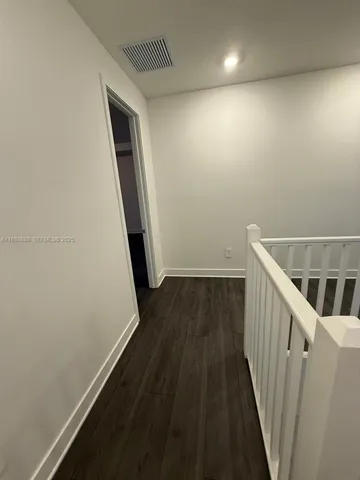 a view of a room with wooden floor