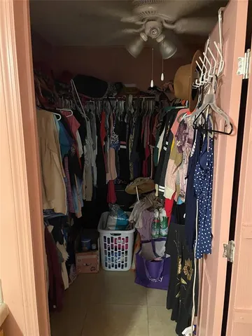 a view of walk in closet with clothes and shoes