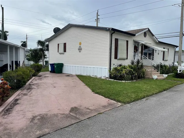 a view of a house with a yard and potted plants