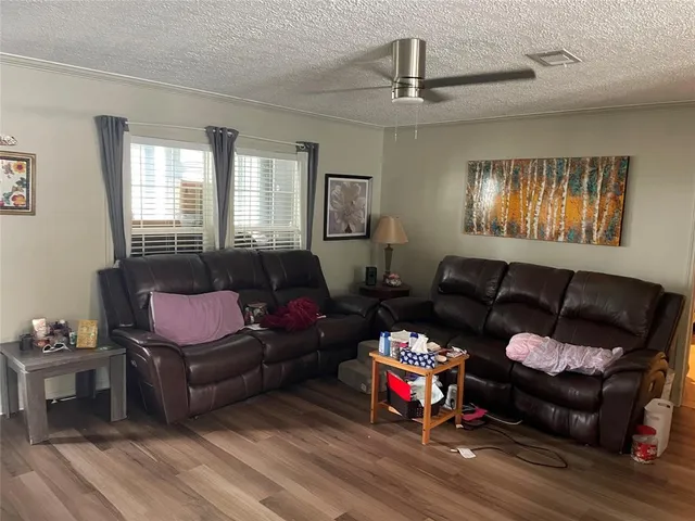 a living room with furniture a ceiling fan and a window
