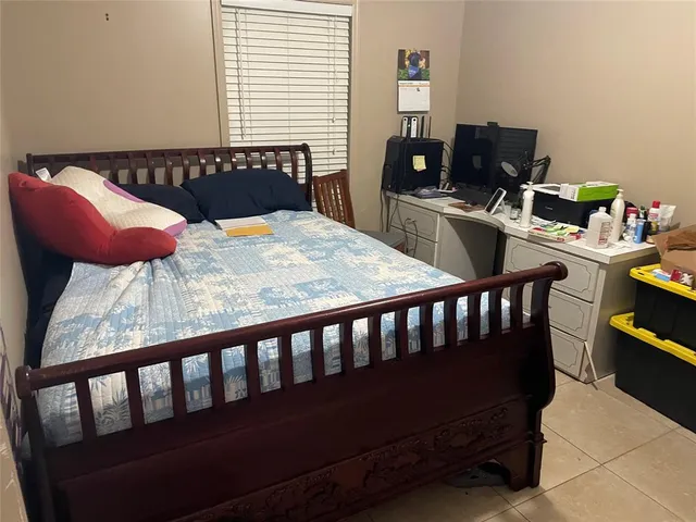 a bedroom with a bed and a computer on a table