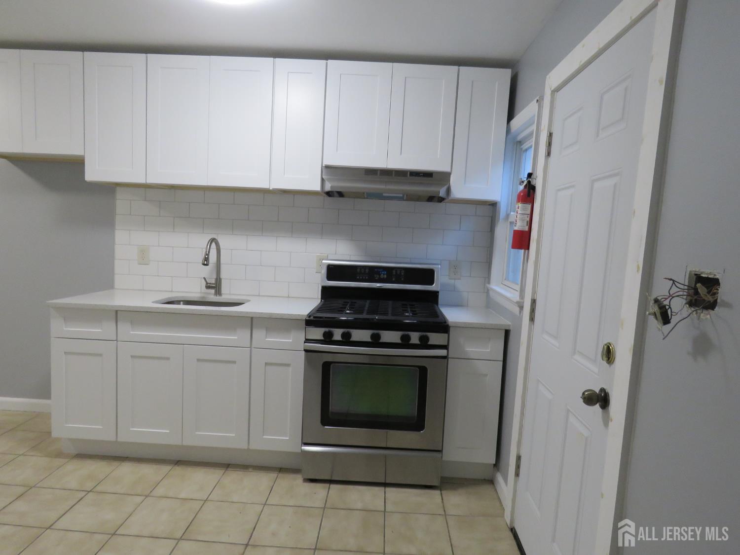768 State Street Perth Amboy, NJ 08861 - Photo 12 of 35 a kitchen with cabinets appliances and a sink