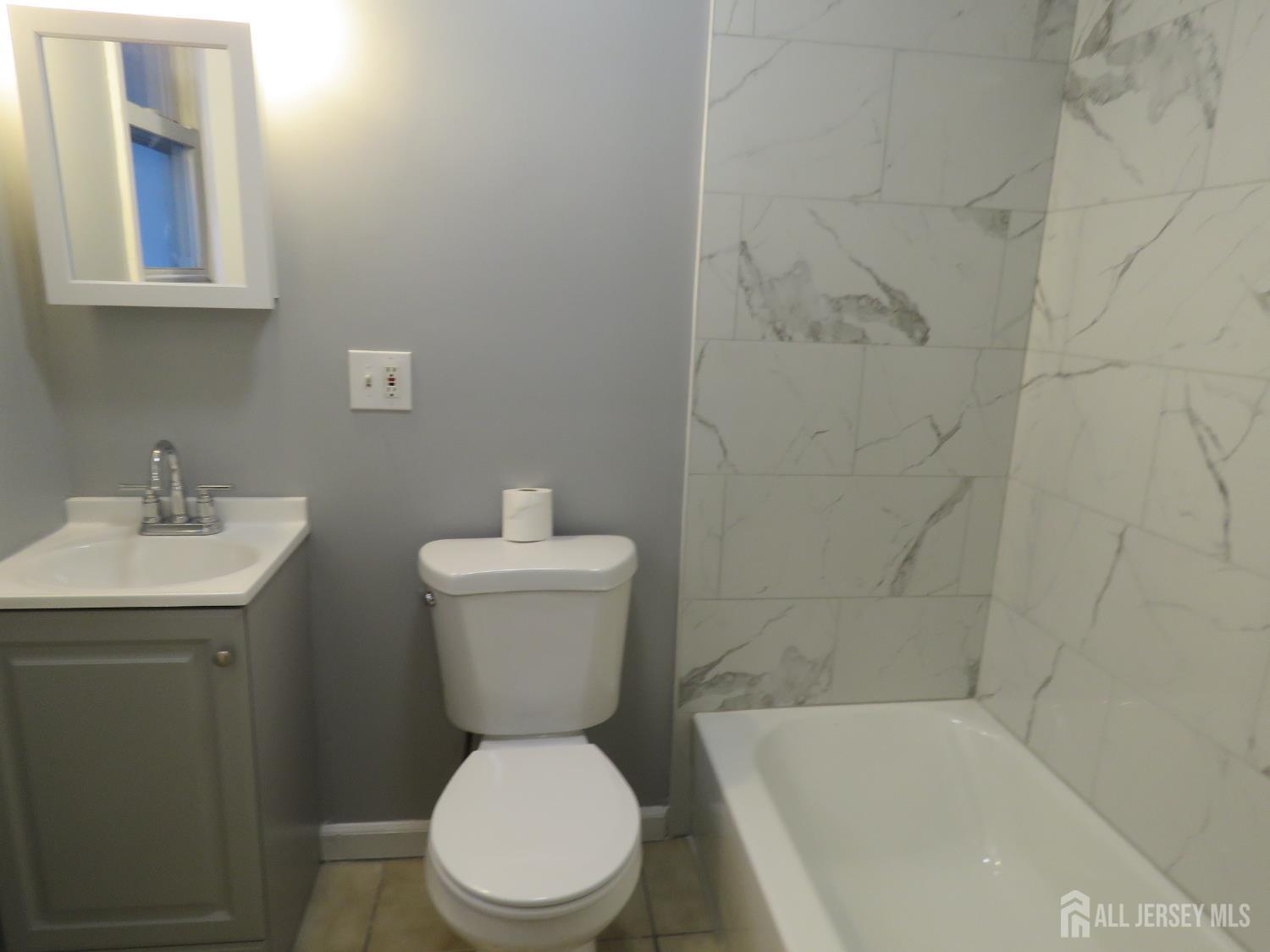 768 State Street Perth Amboy, NJ 08861 - Photo 15 of 35 a white toilet sitting next to a bath tub
