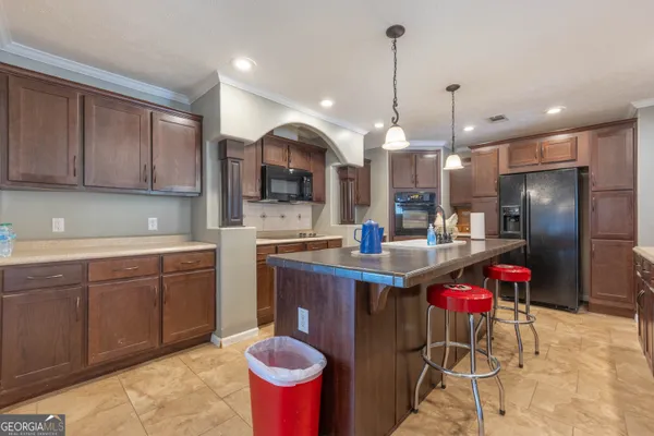 a kitchen with kitchen island a sink stainless steel appliances and a counter top
