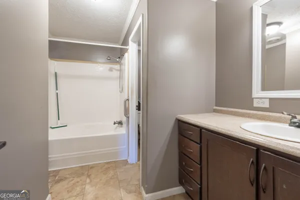 a bathroom with a tub sink and mirror