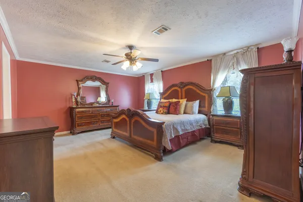 a bedroom with a bed dresser and wooden floor