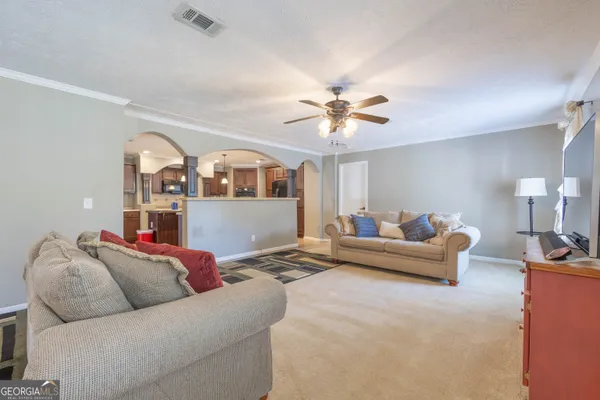 a living room with furniture a chandelier and a flat screen tv