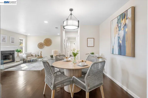 a dining room with furniture a fireplace and wooden floor