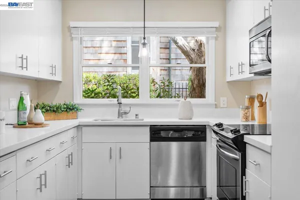a kitchen with stainless steel appliances granite countertop a sink a stove and a window