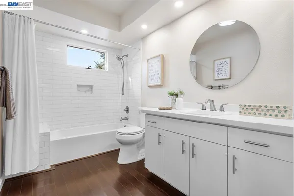 a bathroom with a toilet sink double vanity and mirror