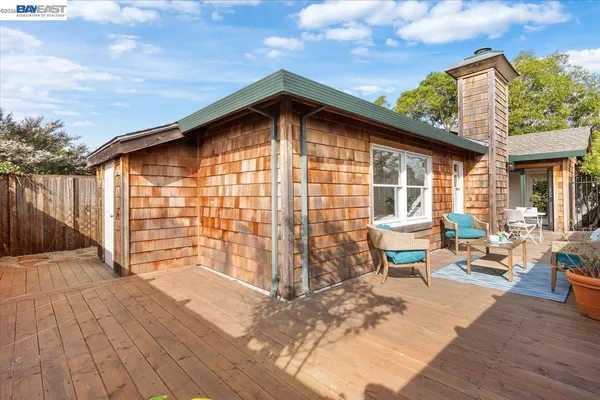 a backyard of a house with barbeque oven and outdoor seating