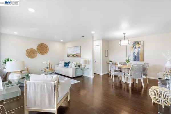 a living room with furniture kitchen view and a large window