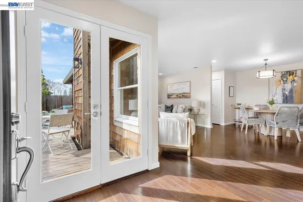 a view of a living room and a dining room with wooden floor
