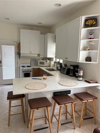 a kitchen with a dining table chairs and white appliances