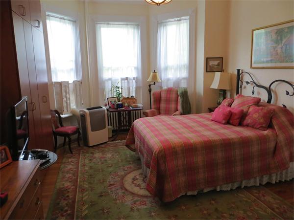 342 Commonwealth Avenue, Unit 3 Boston, MA 02115 - Photo 2 of 6 a bedroom with a bed gym equipment and a large window