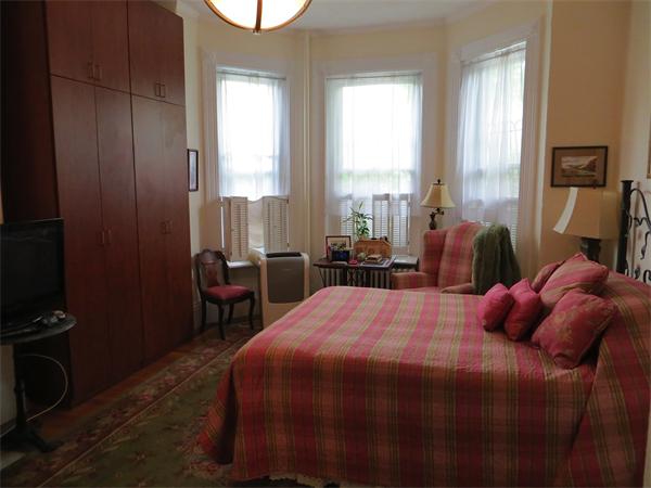 342 Commonwealth Avenue, Unit 3 Boston, MA 02115 - Photo 3 of 6 a bedroom with a bed a table and three windows