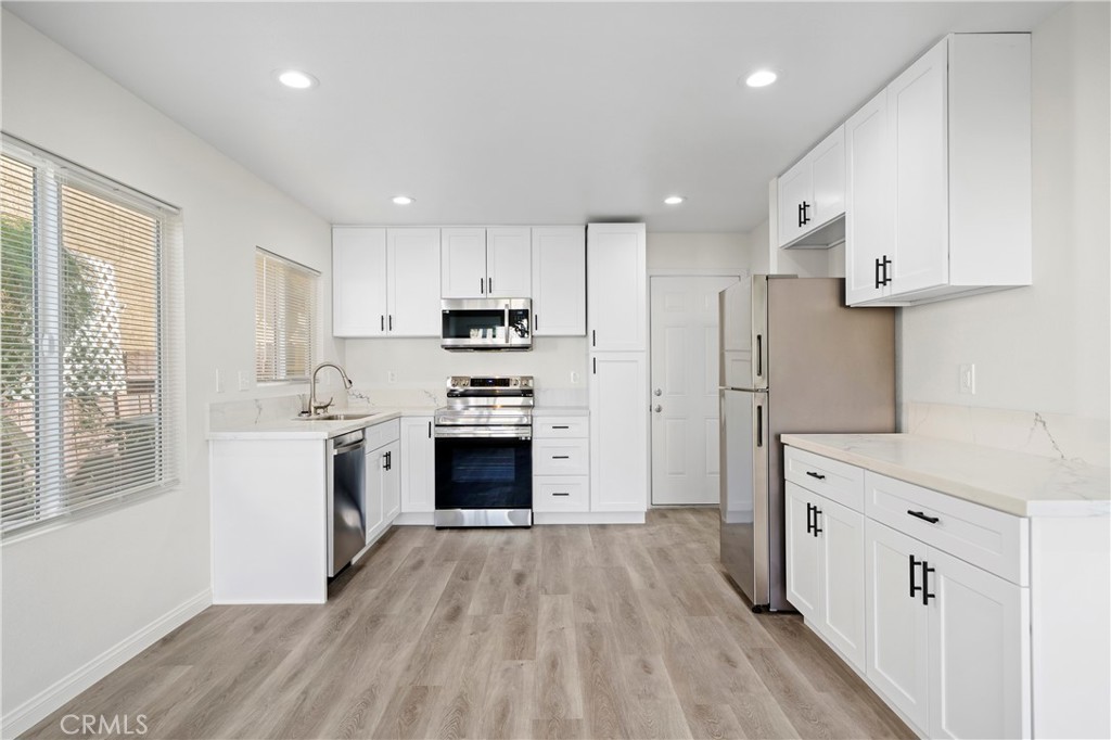 33034 Romero Drive Temecula, CA 92592 - Photo 9 of 21 a kitchen with cabinets wooden floor and stainless steel appliances