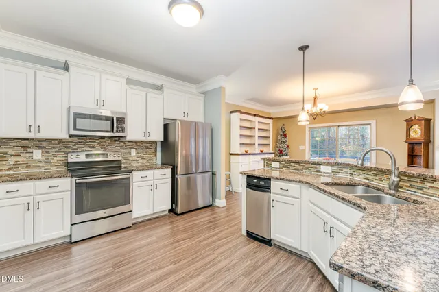 a kitchen with granite countertop a sink cabinets and wooden floor