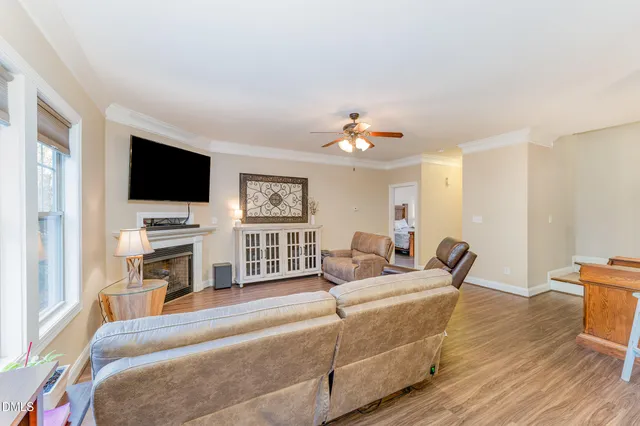 a kitchen with stainless steel appliances granite countertop a stove a sink dishwasher a refrigerator and white cabinets with wooden floor