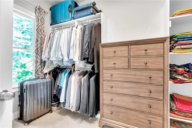 a view of walk in closet with clothes and shoes