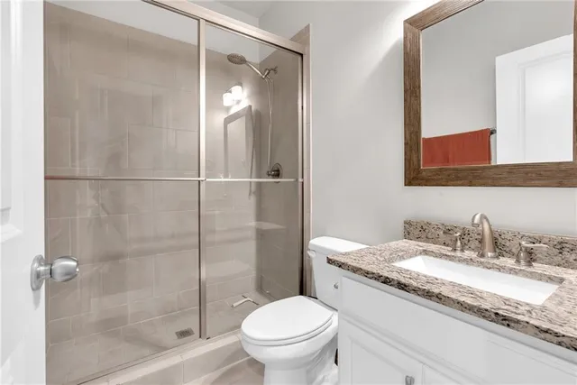 a bathroom with a granite countertop sink toilet and shower