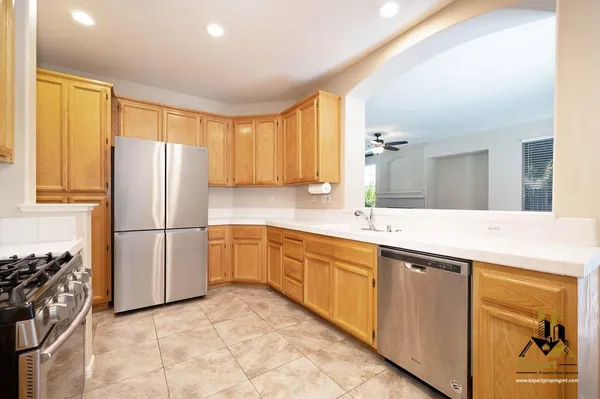 a kitchen with stainless steel appliances granite countertop a refrigerator and a sink