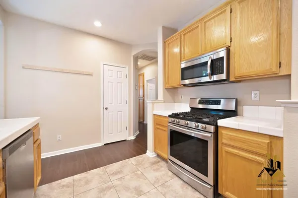 a kitchen with stainless steel appliances granite countertop a stove a microwave and a refrigerator