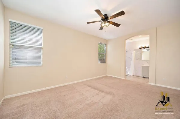 a view of a livingroom with a ceiling fan and window