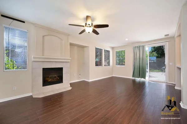 a view of empty room with wooden floor and fireplace