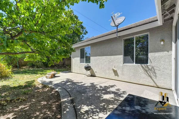 a backyard of a house with table and chairs