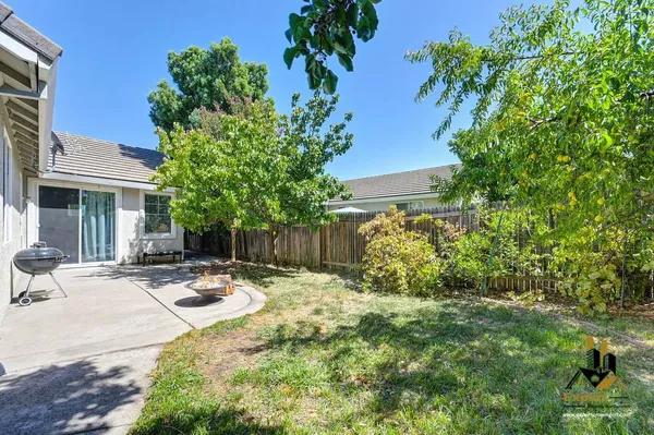 a view of a backyard with table and chairs and a tree