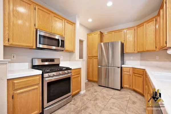 a kitchen with stainless steel appliances granite countertop a refrigerator stove and microwave